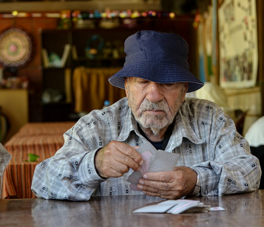 Homem idoso lendo papéis sentado à mesa