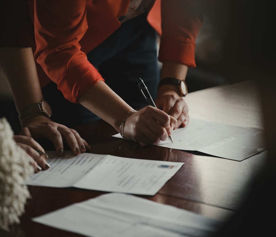 Pessoas assinando documentos sobre uma mesa